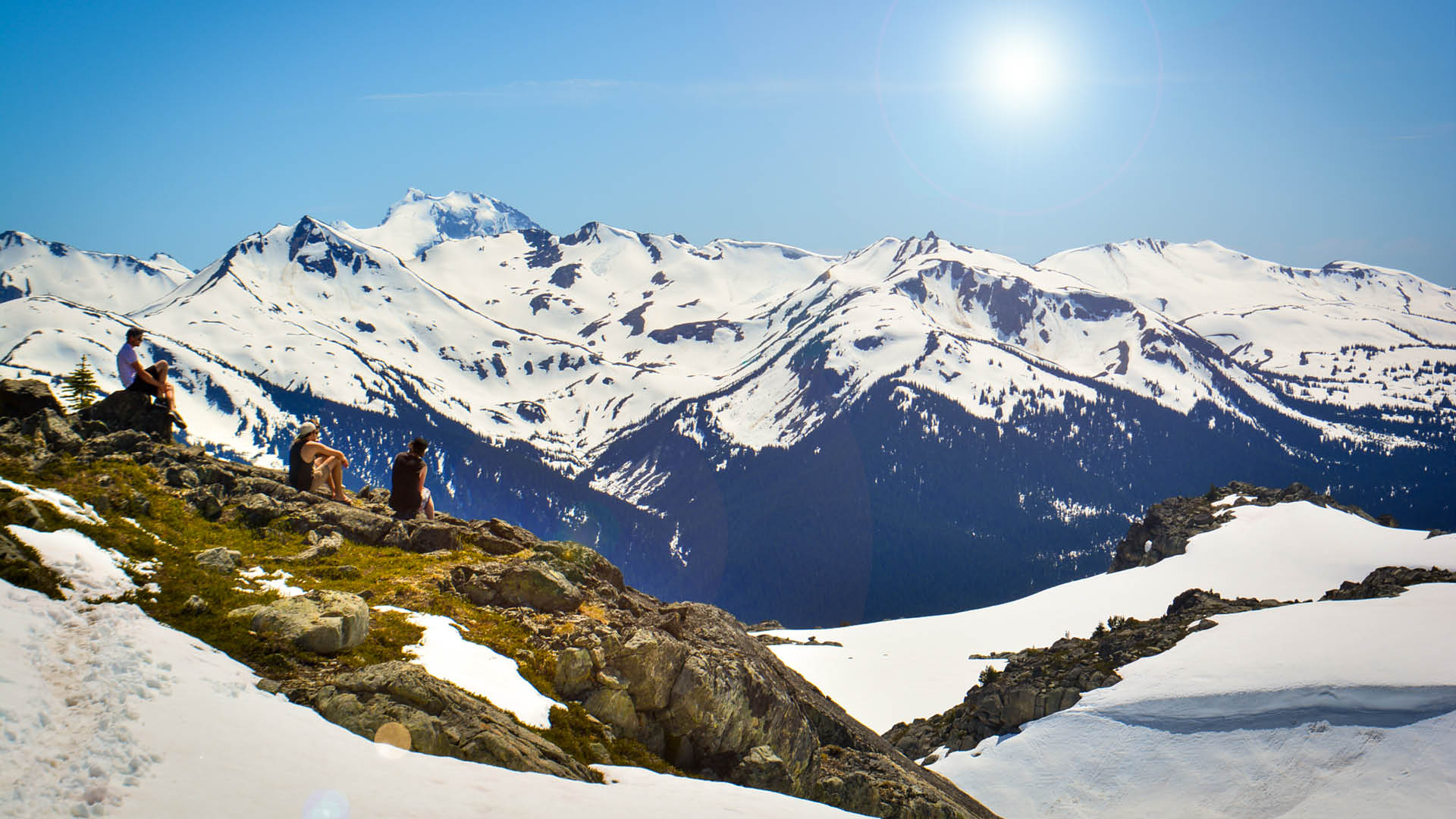 people sitting on rocks, looking at mountain views